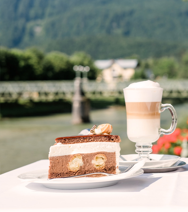 Schnappschuss von Kaffee und Torte im Zauner Cafe und Restaurant Esplanade Außenbereich im Hintergrund der Traunfluss