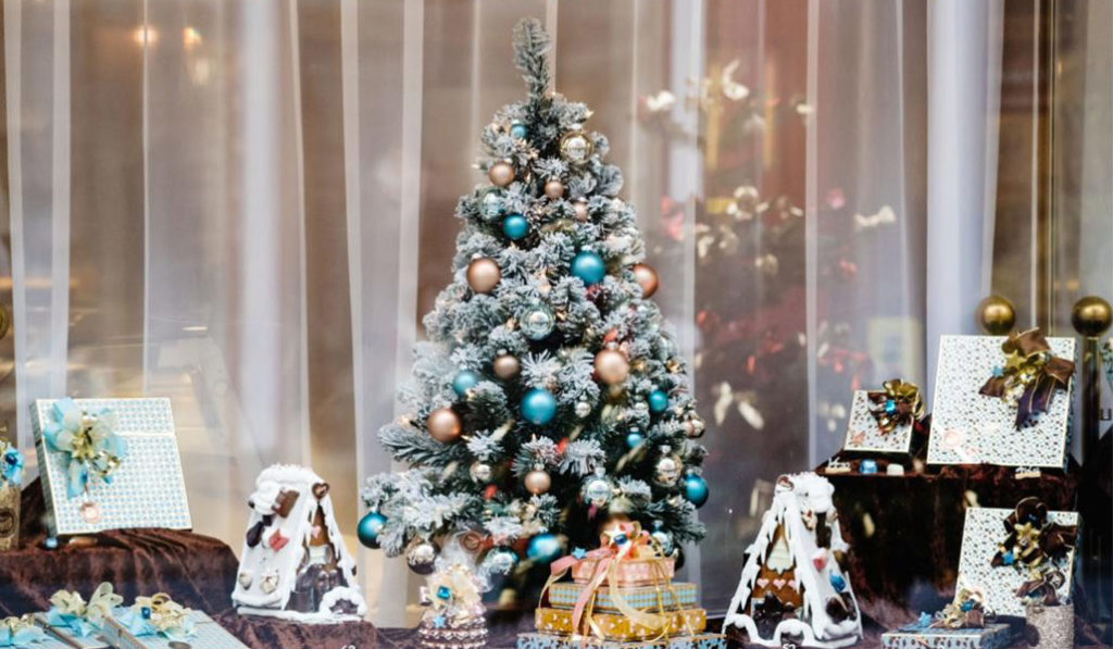 Christmas shop window with a small Christmas tree and gingerbread house.