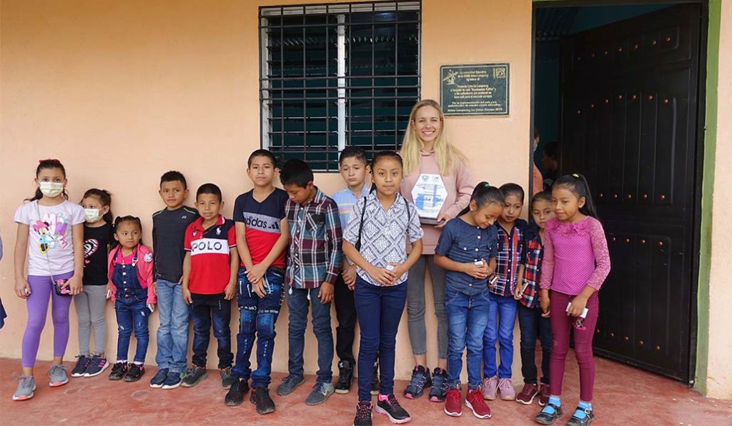 Marlene Drack lined up in front of a wall with school children.