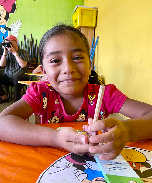 Schoolchild with a pen at the Nussbaumer School looks gently smiling into the camera.