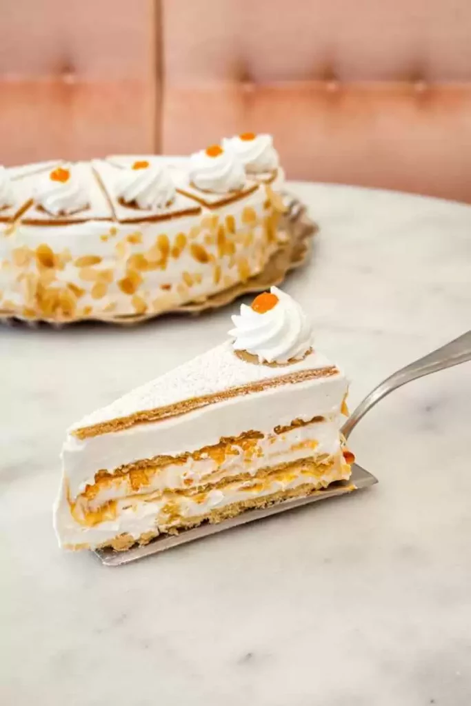 Piece of cake on cake fork. In the background is the rest of the cake.