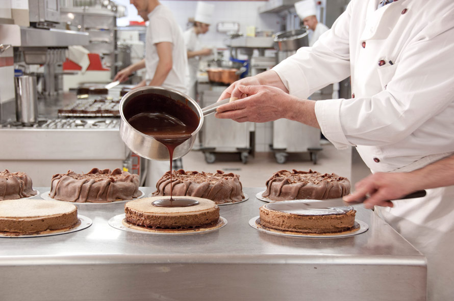 View of the bakery. Cakes are covered with liquid chocolate.