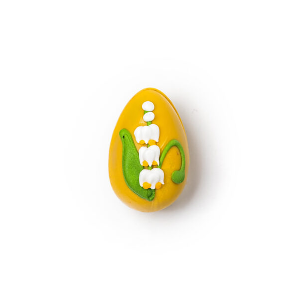 Yellow chocolate egg with passion fruit and Easter decoration